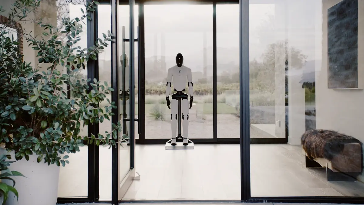 The Figure 03 robot stands on a sleek, white wireless charging pad.