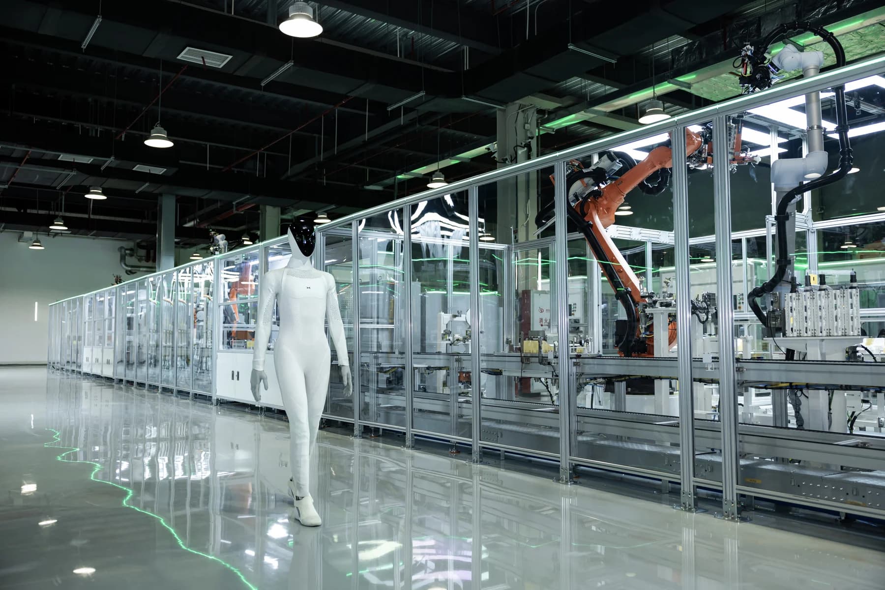IRON standing beside automated equipment on XPENG’s robot production line