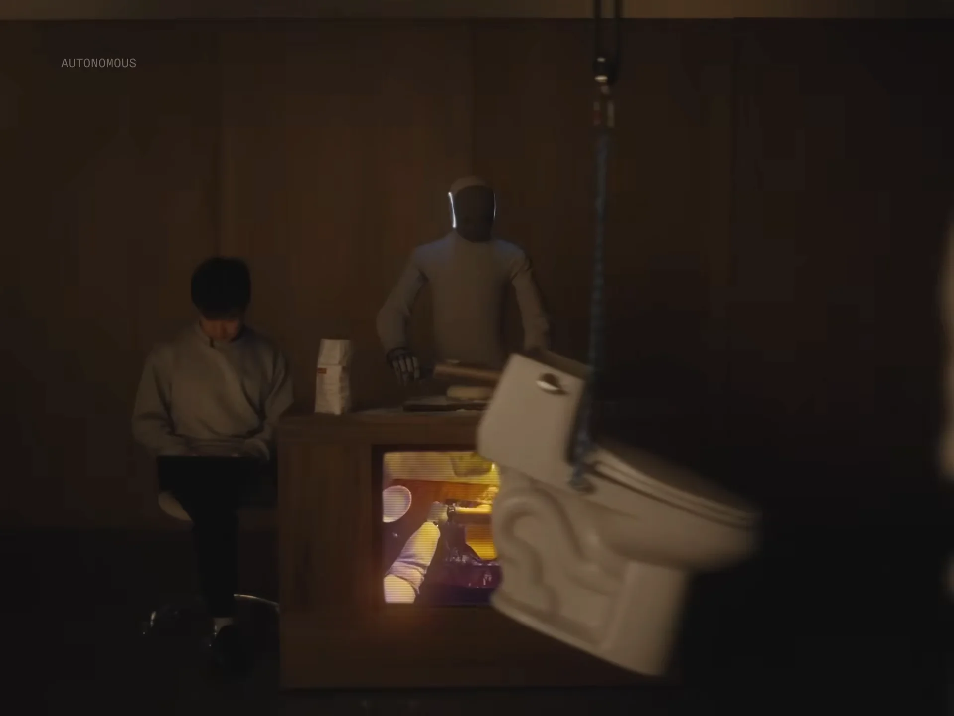 NEO robot in a dimly lit, chaotic room with a toilet seat swinging from the ceiling and a human sitting to the side.