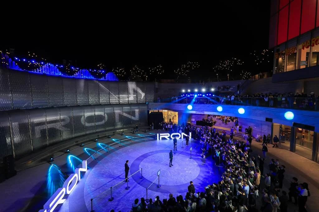 Wide shot of the Xpeng Iron event at night with a large crowd.