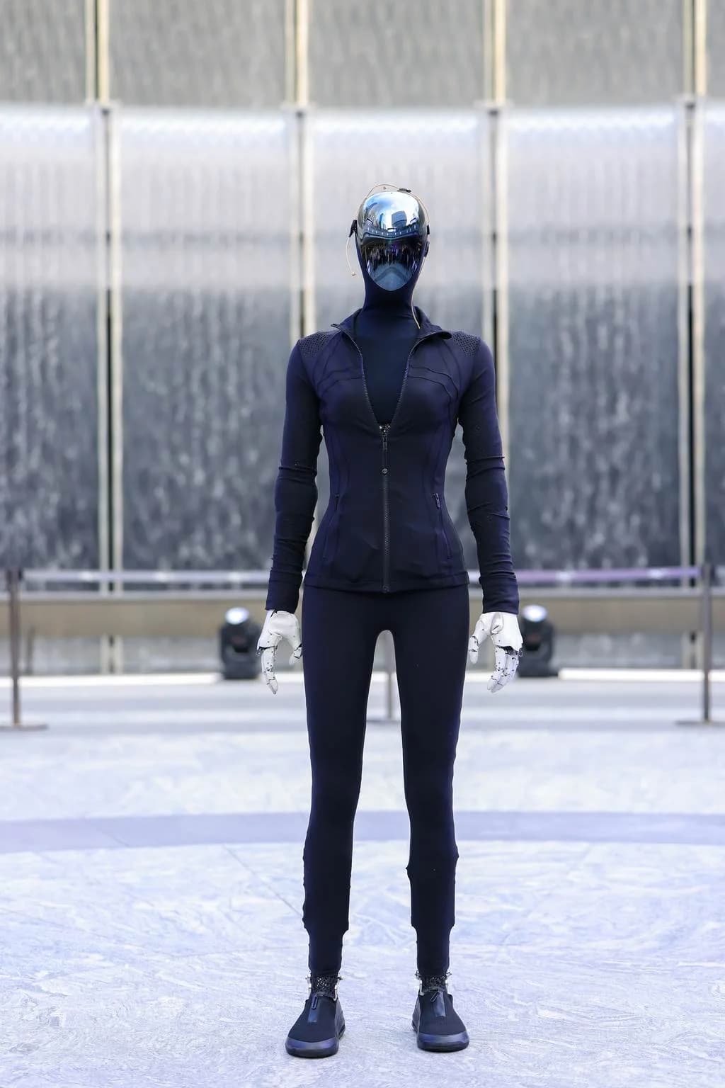 Front view of Xpeng Iron showing the mirrored visor and gloved hands.