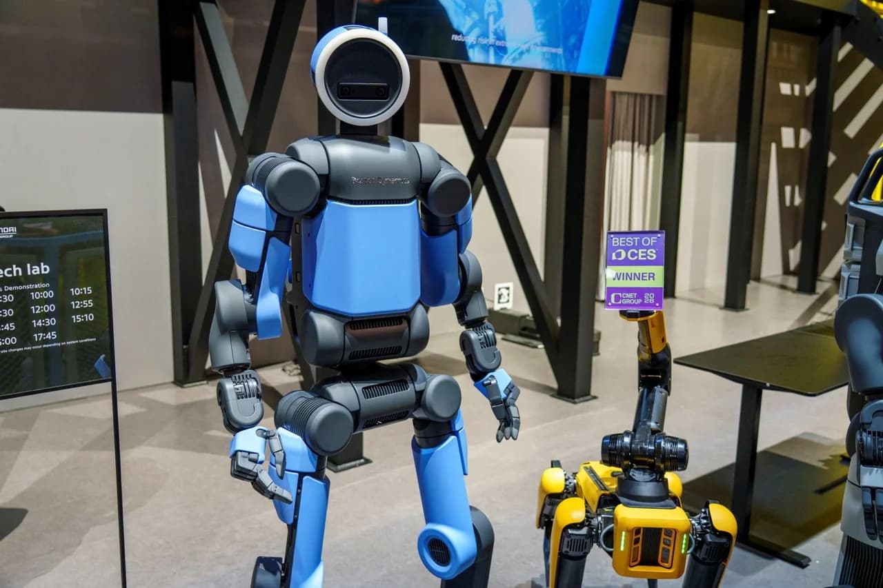The production-ready blue and black Atlas robot stands on a display stage next to a "Best of CES Winner" sign at CES 2026.