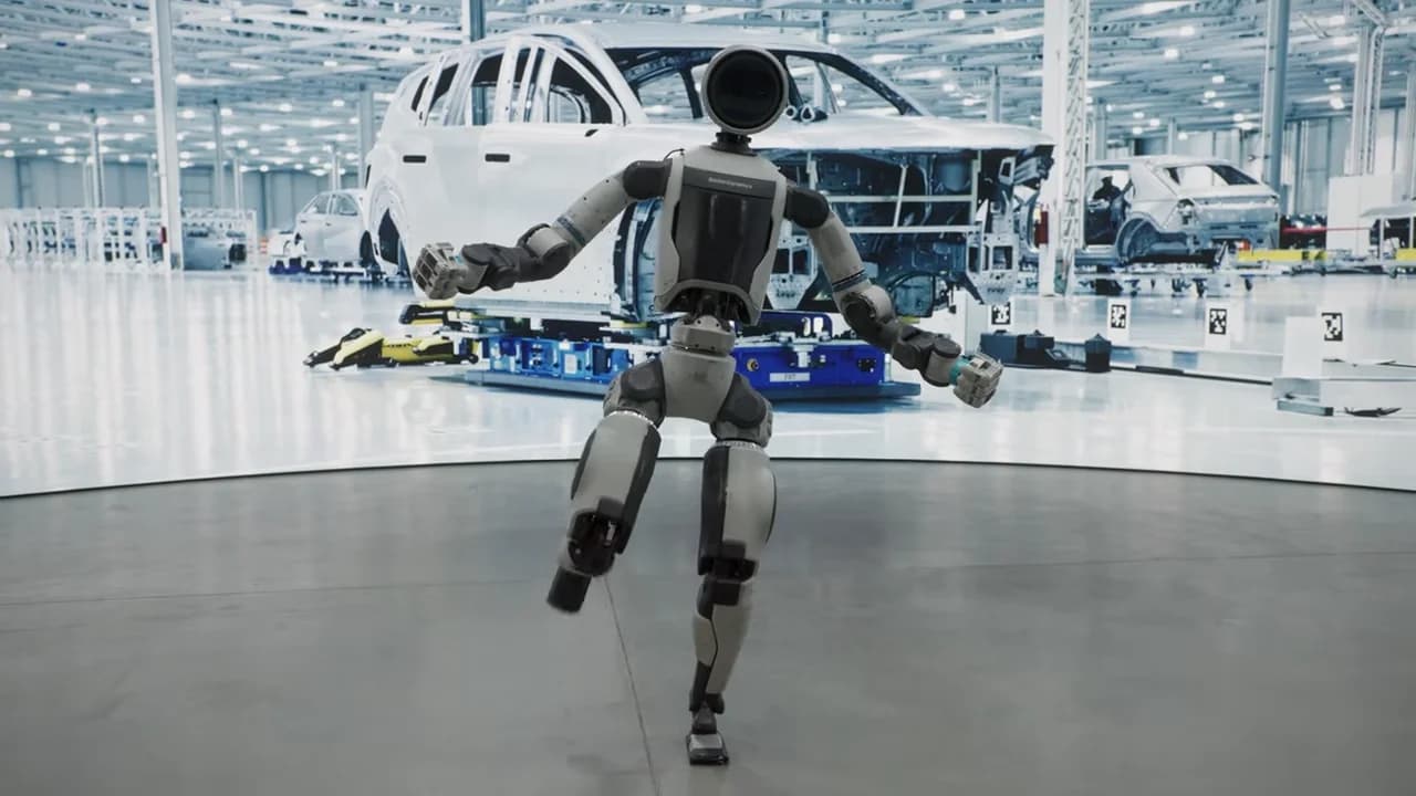 The all-electric Atlas humanoid balancing effortlessly on one leg with its torso upright and other leg extended, demonstrating the robot's high degree of freedom and active dynamic stability control.