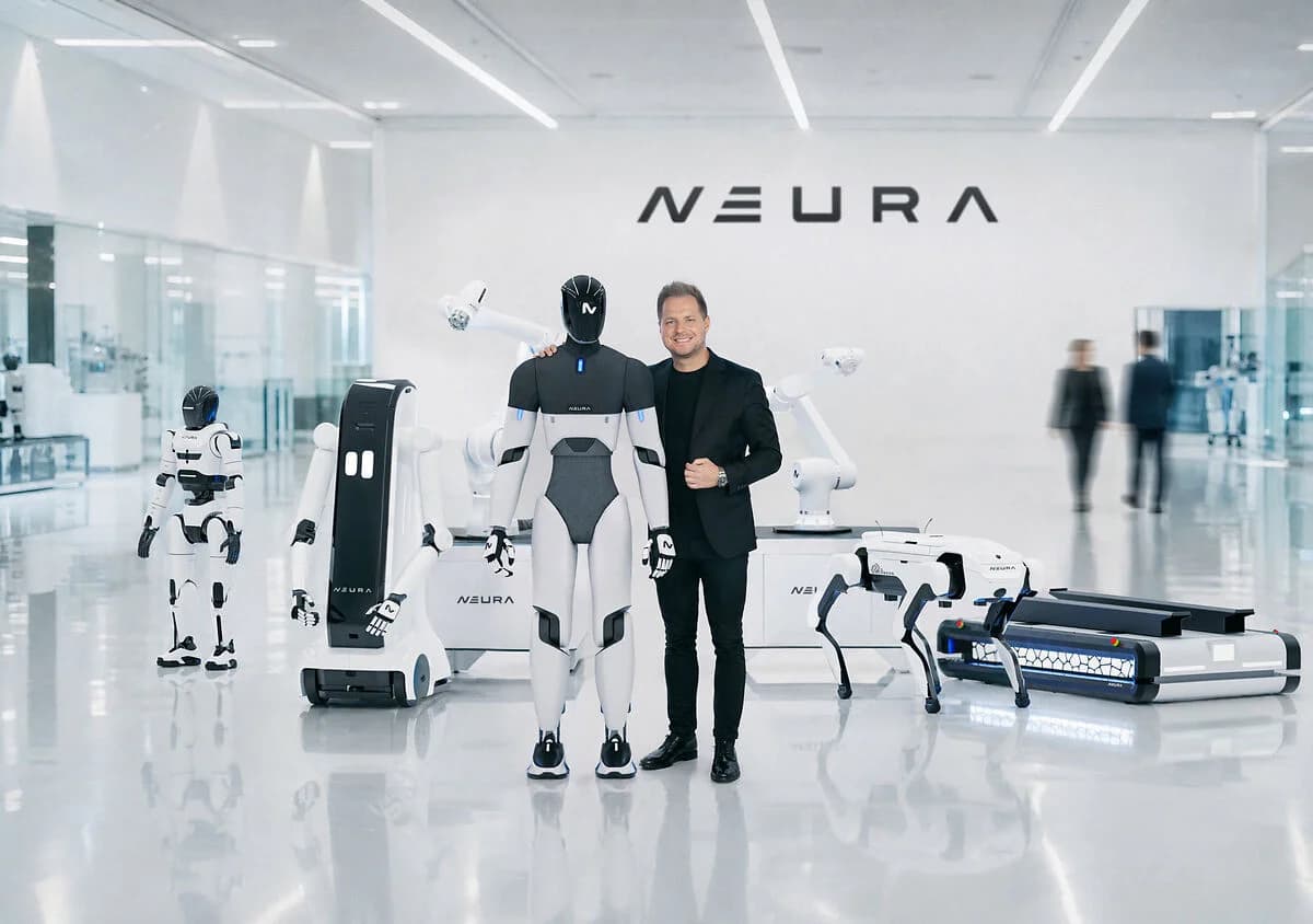NEURA Robotics CEO David Reger stands in a bright, modern facility next to a 4NE-1 humanoid robot. They are surrounded by the company's broader product lineup, including the MiPA service robot, a robotic arm, a quadruped, and an autonomous mobile robot.