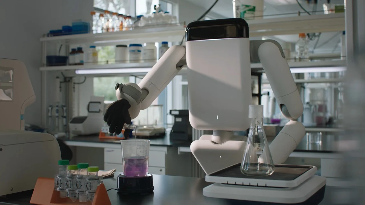 The Eno robot standing at a laboratory bench, using its black-gloved robotic hand to carefully pour liquid from a test tube into a beaker filled with purple fluid.