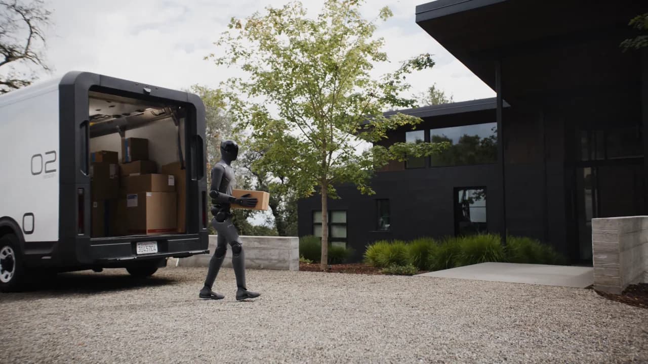A gray Figure 03 humanoid robot carrying a package from a delivery van