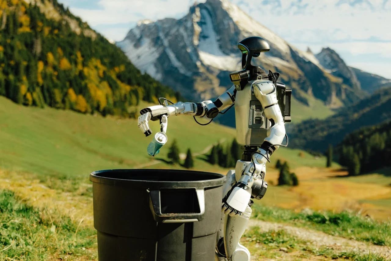 A modified Unitree G1 robot, equipped with a custom neck-mounted camera array, drops a crushed soda can into a trash bin against a mountainous Swiss backdrop.
