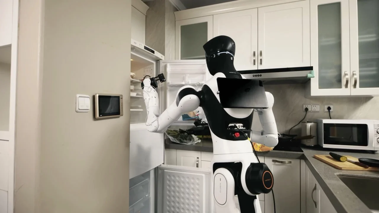 An AGIBOT G2 robot seen from behind in a modern kitchen, reaching into an open refrigerator with its robotic arm to perform a restocking task.