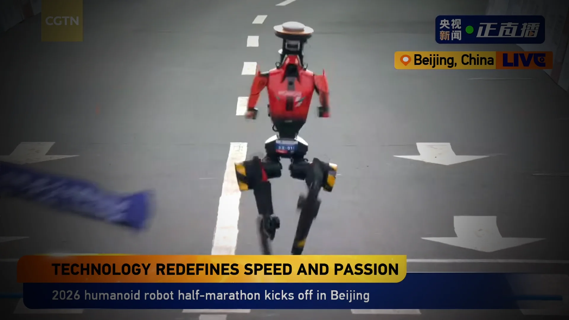 An overhead action shot of a red and black Honor Lightning humanoid robot sprinting across the finish line on a city street in Beijing. The robot is captured in a clear flight phase with both feet off the ground, passing a blue finish-line tape. A CGTN news overlay at the bottom reads 'TECHNOLOGY REDEFINES SPEED AND PASSION'.