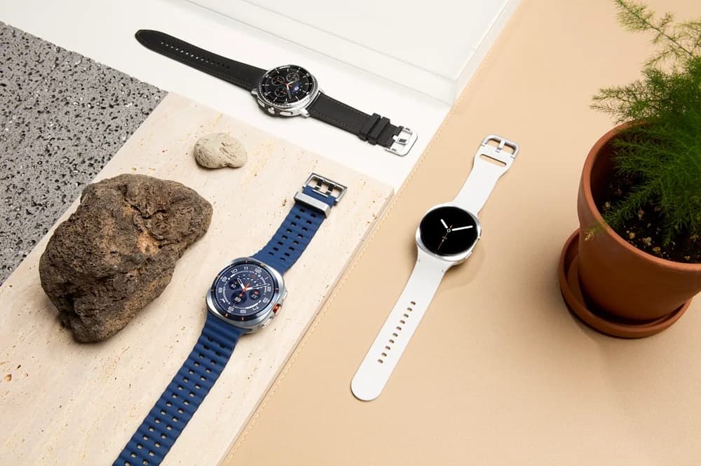 A flat-lay arrangement of three smartwatches: the squircle-shaped Galaxy Watch 8, the Galaxy Watch 8 Classic with a physical rotating bezel, and the rugged titanium Galaxy Watch Ultra.