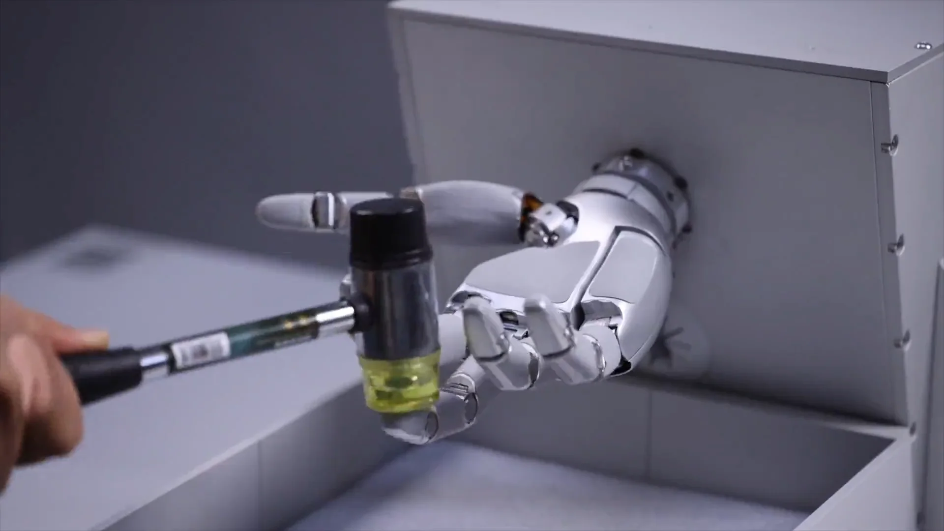 A SharpaWave robotic hand mounted on a test rig being struck by a mallet during impact testing.