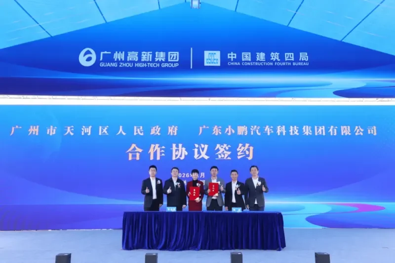 Six people stand on a stage for a formal signing ceremony in front of a large blue digital backdrop. Two individuals in the center hold red folders. The screen features text in Chinese identifying the Guangzhou Tianhe District People's Government and Guangdong Xiaopeng Motors Technology Group Co., Ltd. for a "Cooperation Agreement Signing."