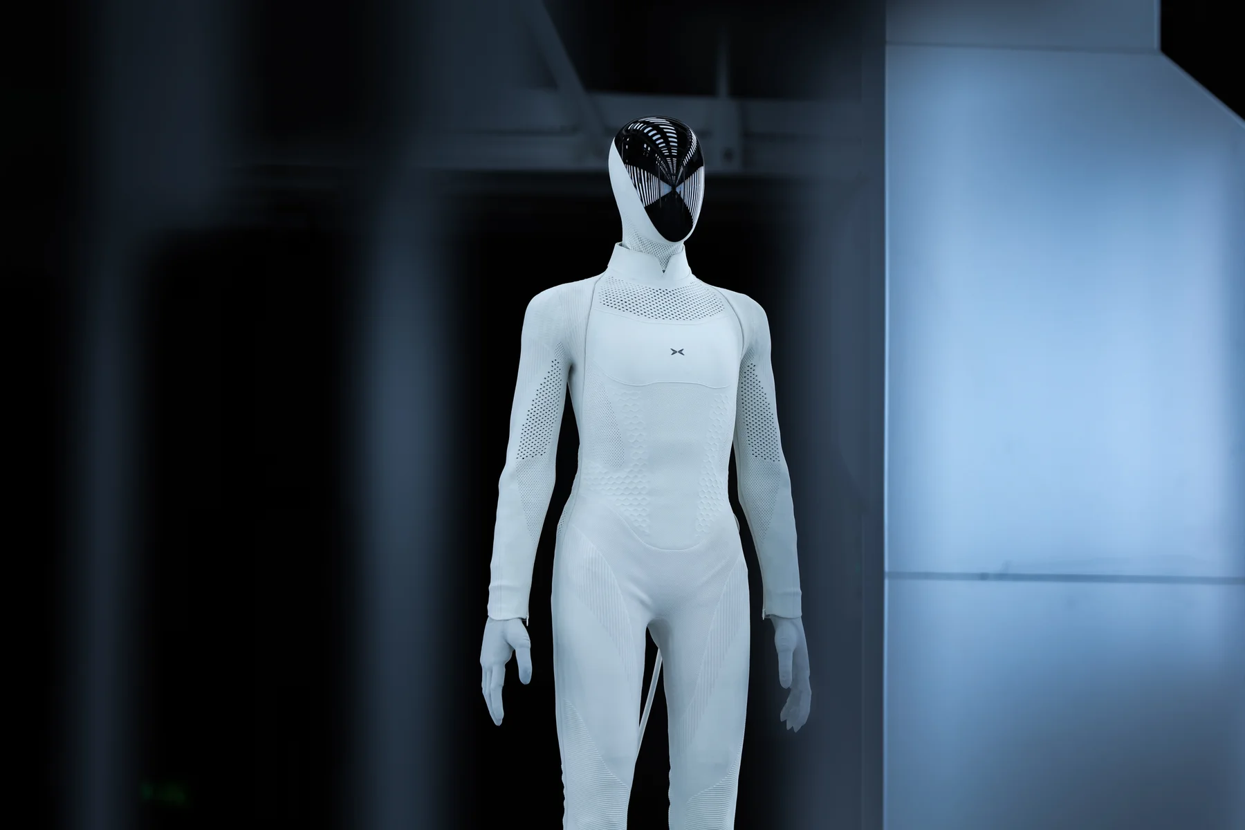 Production-version XPENG IRON in a white bodysuit against a dark background