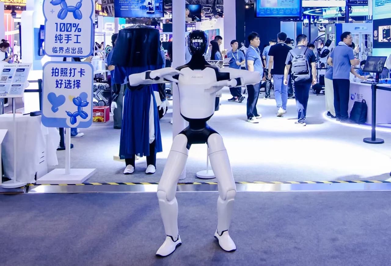 A full-size white and black AGIBOT A3 Ultra humanoid robot holding a wide athletic squat stance on the WAIC 2026 exhibition floor.