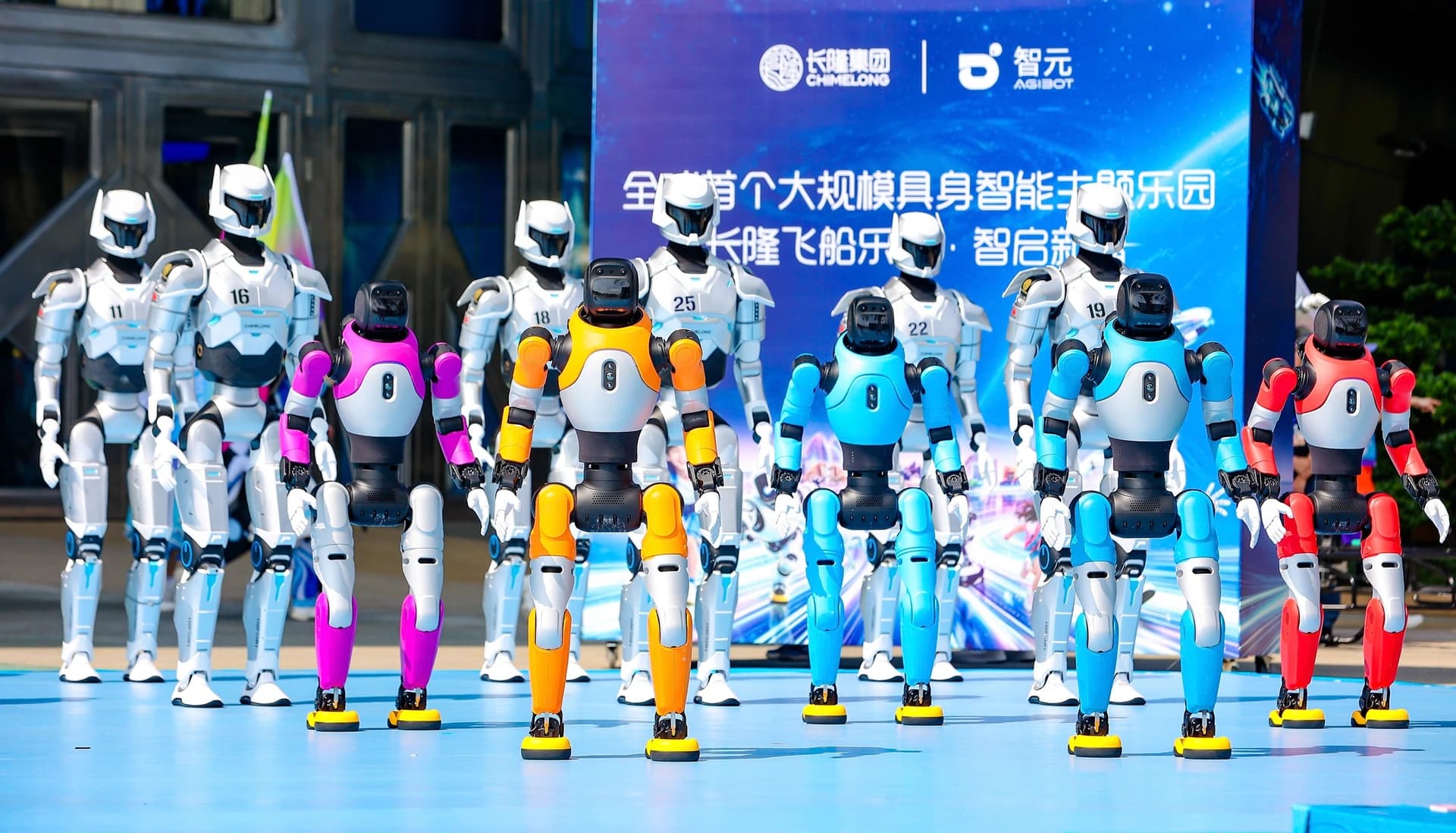 Colorful AGIBOT humanoid robots lined up in front of an AGIBOT and Chimelong event backdrop.