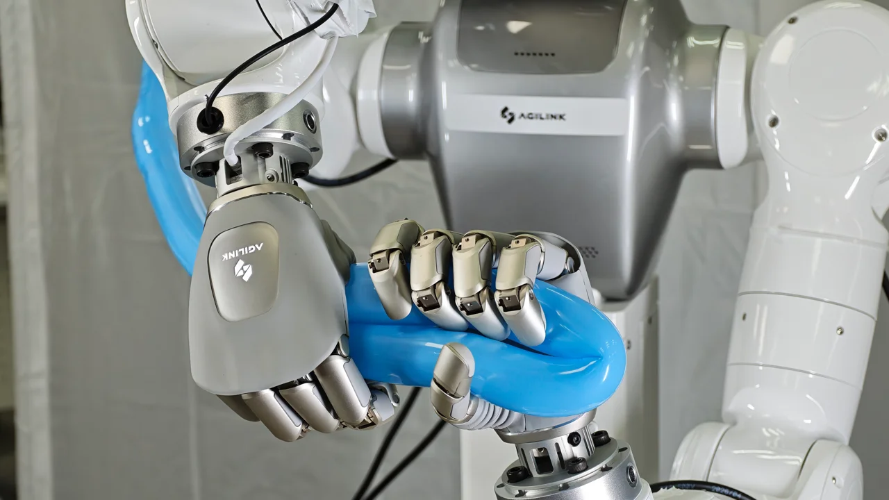 Two OmniHand 3 Ultra-M robotic hands closely twisting and shaping a long blue balloon.