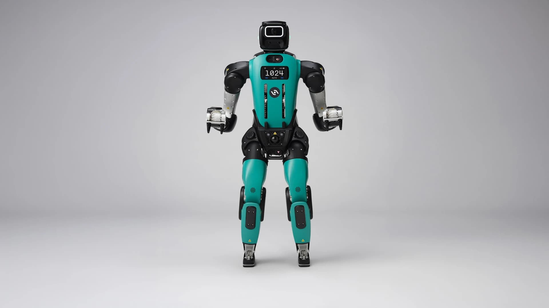 Front view of Agility's Digit 5 humanoid robot, with a teal torso and legs, black head and compact grippers, against a gray background.