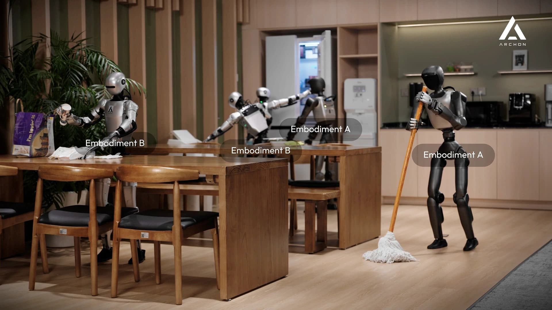 Five humanoid robots performing tasks in a shared kitchen and dining space, including a robot holding a mop.