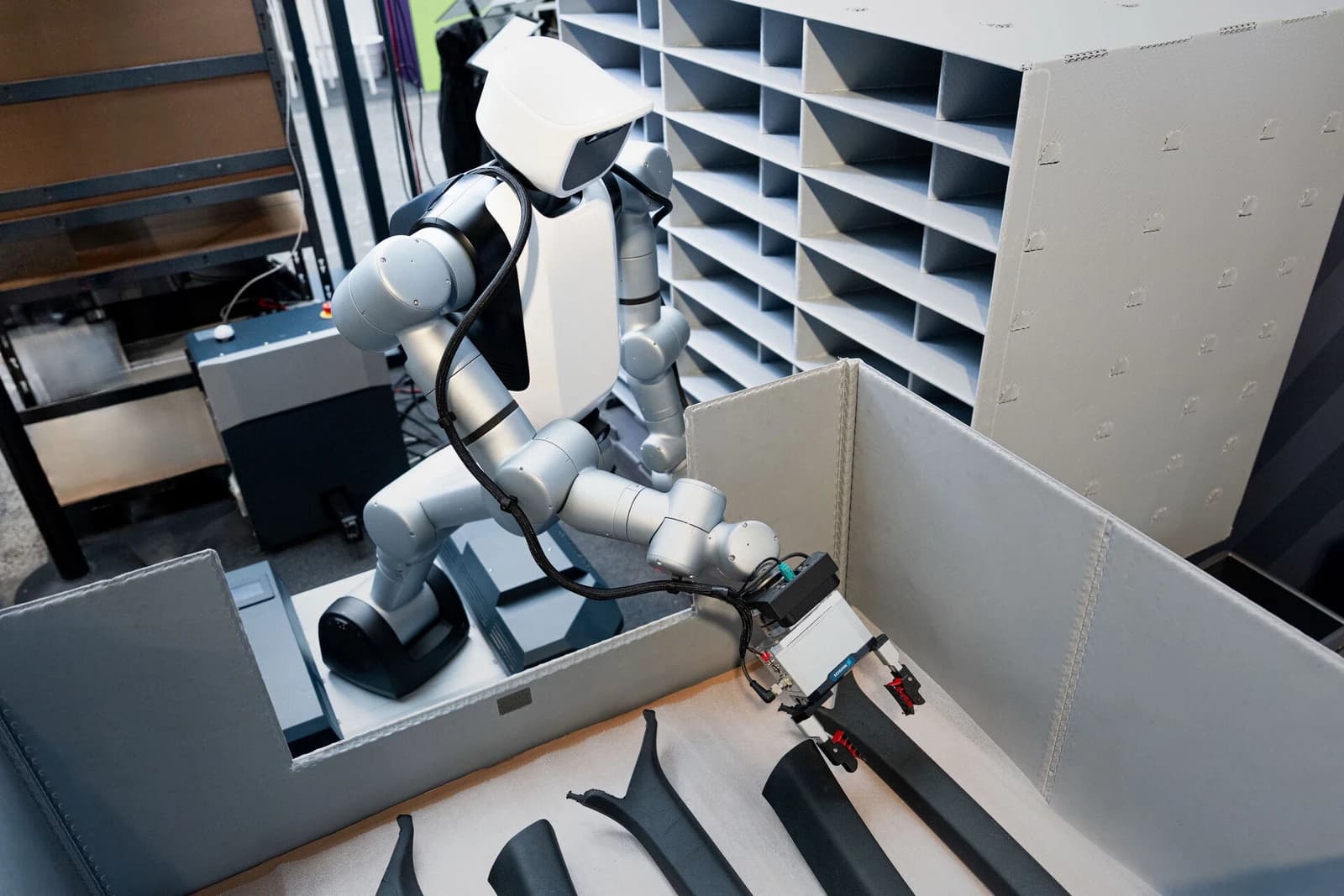 An Agile Robots humanoid reaches into a container holding automotive components.