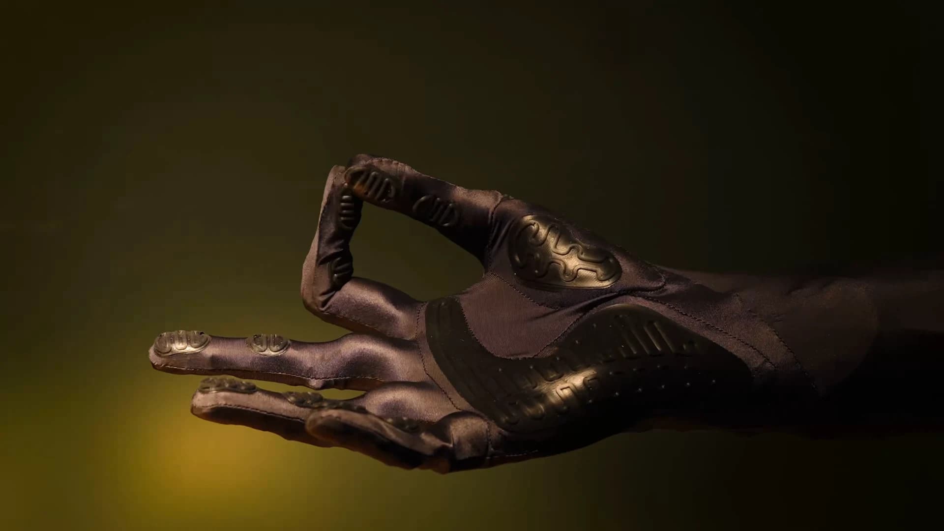 A close-up of Clone’s gloved robotic hand with its thumb and index finger touching.