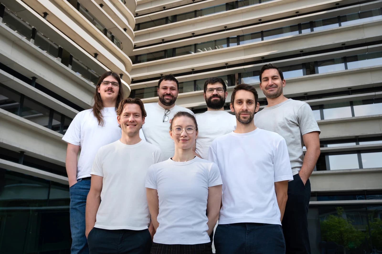 Seven members of the Enact team standing outside a building.