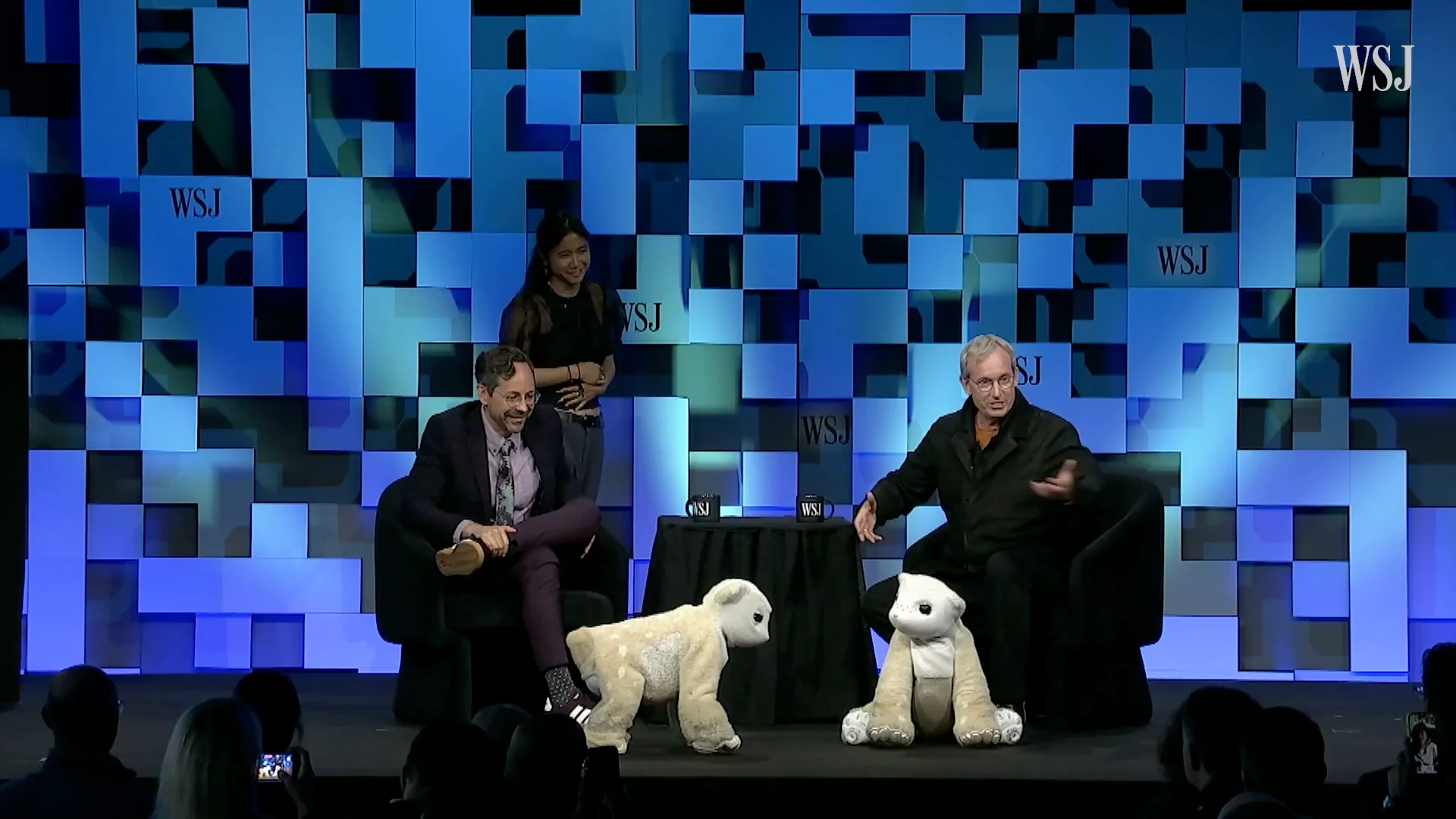 iRobot co-founder Colin Angle and Christopher Mims sit on stage at the WSJ Future of Everything conference alongside two quadruped Familiar prototypes.