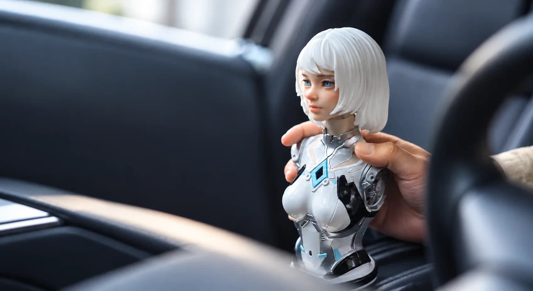 Figurobot’s FR-NIA companion robot with white hair and a silver torso, held inside a car.