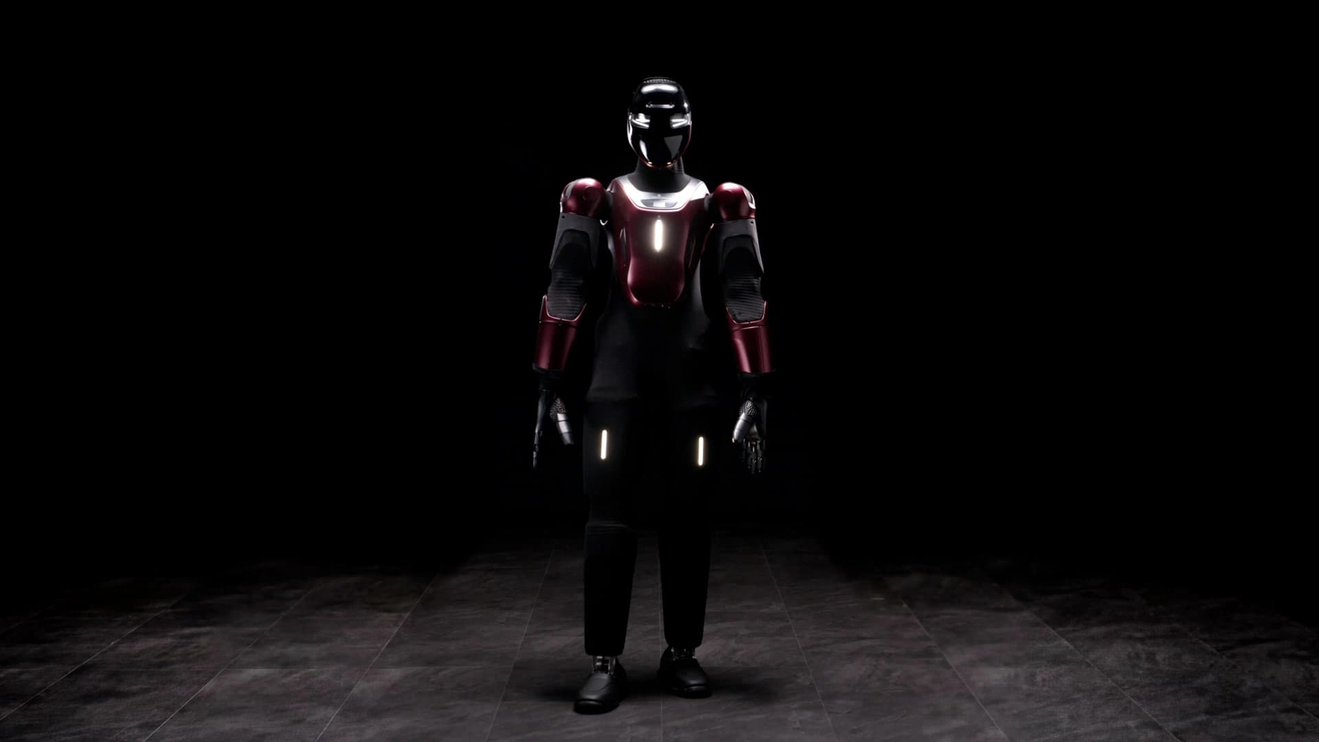 A full-body view of the GENE.01 humanoid robot standing in a sparsely lit room. It features a sleek black and burgundy outer shell, a glossy black visor with illuminated white eyes, and glowing indicator lights on its chest and thighs.