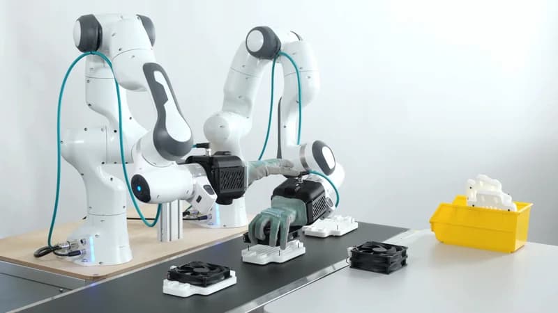 Mimic robotic hands attached to cobot arms working on assembly of computer parts