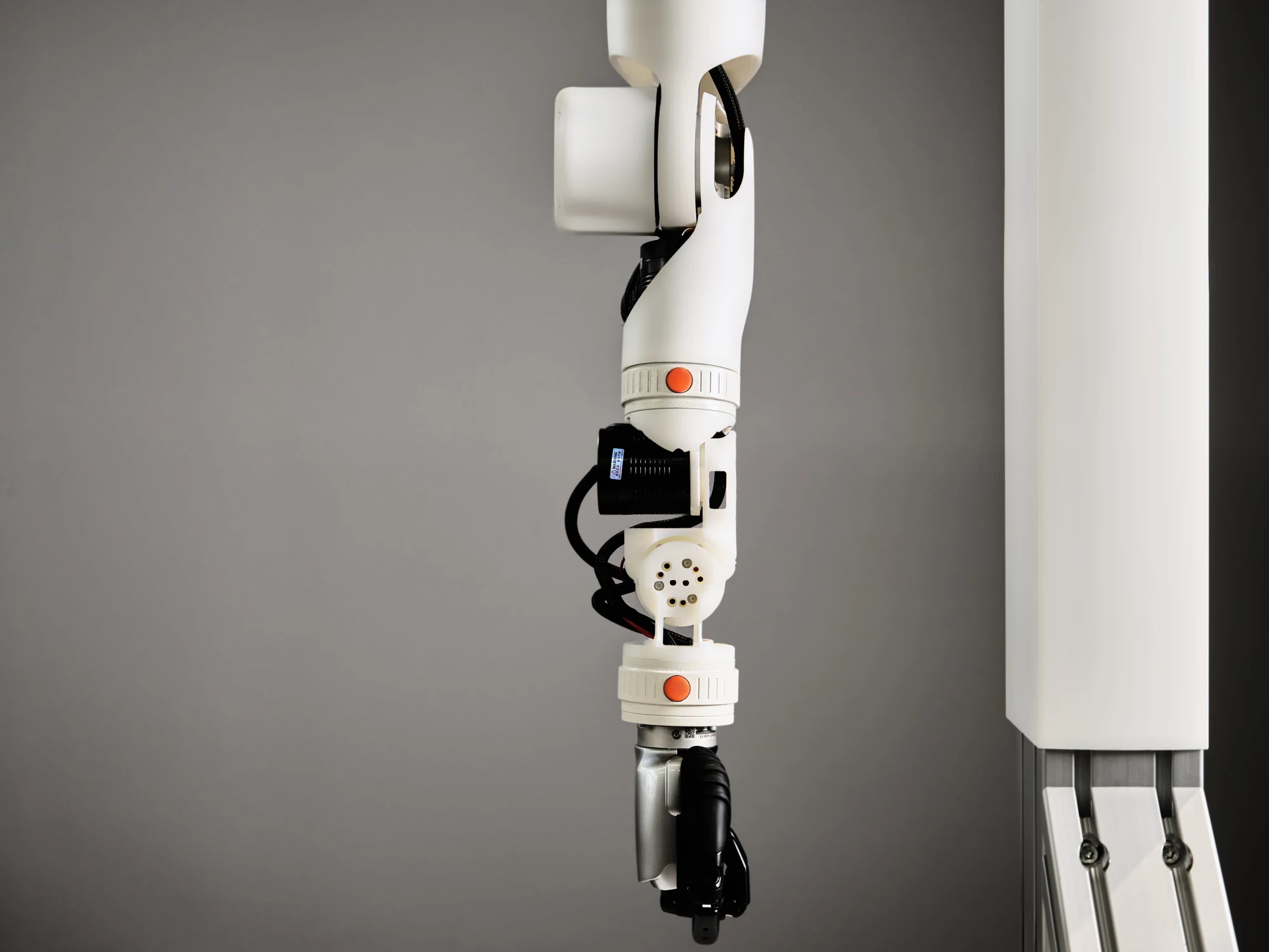 Close-up of an O-ID prototype arm showing its wrist, gripper and modular connections with orange buttons.