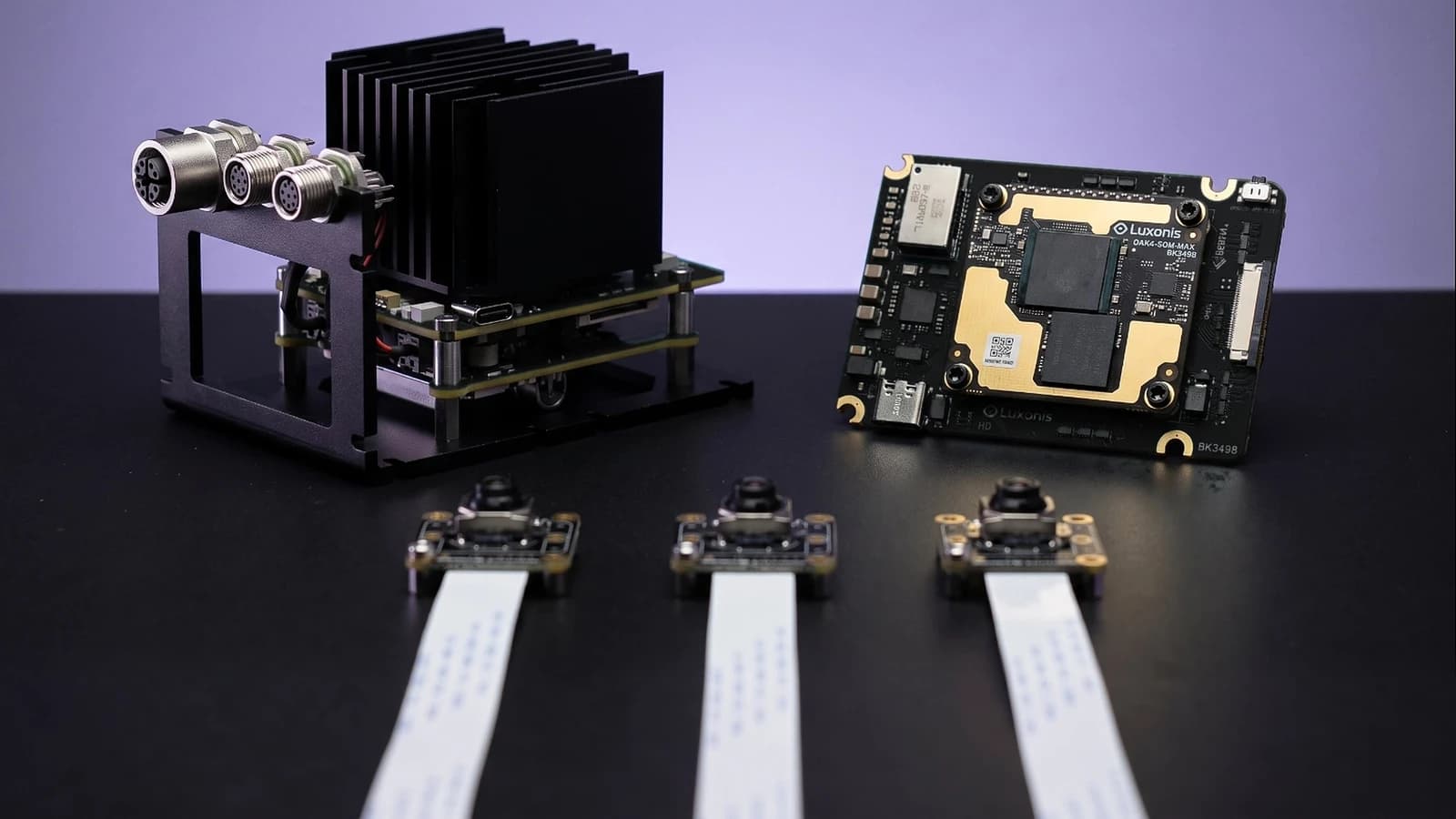 OAK 4 FFC developer kit, circuit board and three camera modules on a dark tabletop.