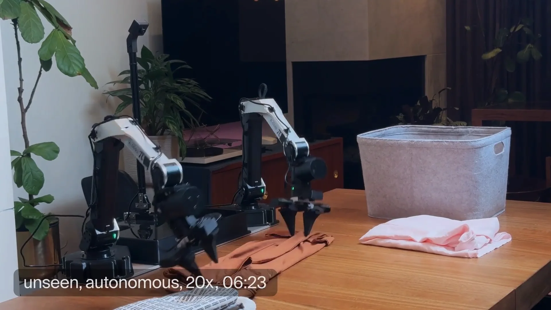 Robot arms folding a garment on a table.