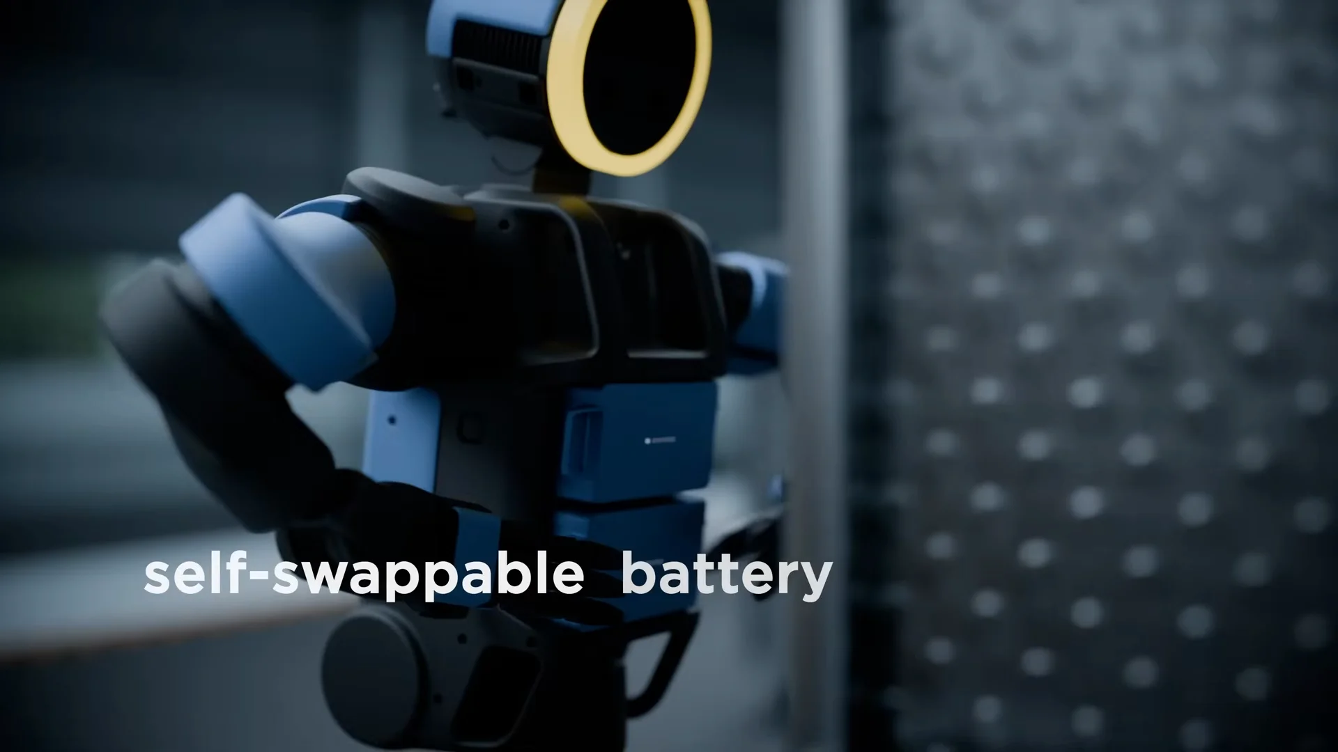 A close-up side view of the Atlas robot with the text "self-swappable battery" overlaid in white. The robot’s hand is positioned near its torso where the dual battery compartments are located.