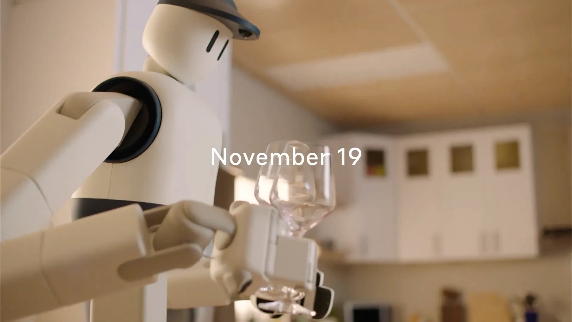 A close-up of the Sunday Robotics robot, showing a minimalist white head with two simple black vertical 'eyes' and a dark-colored cap, emerging from a doorway in a home kitchen.