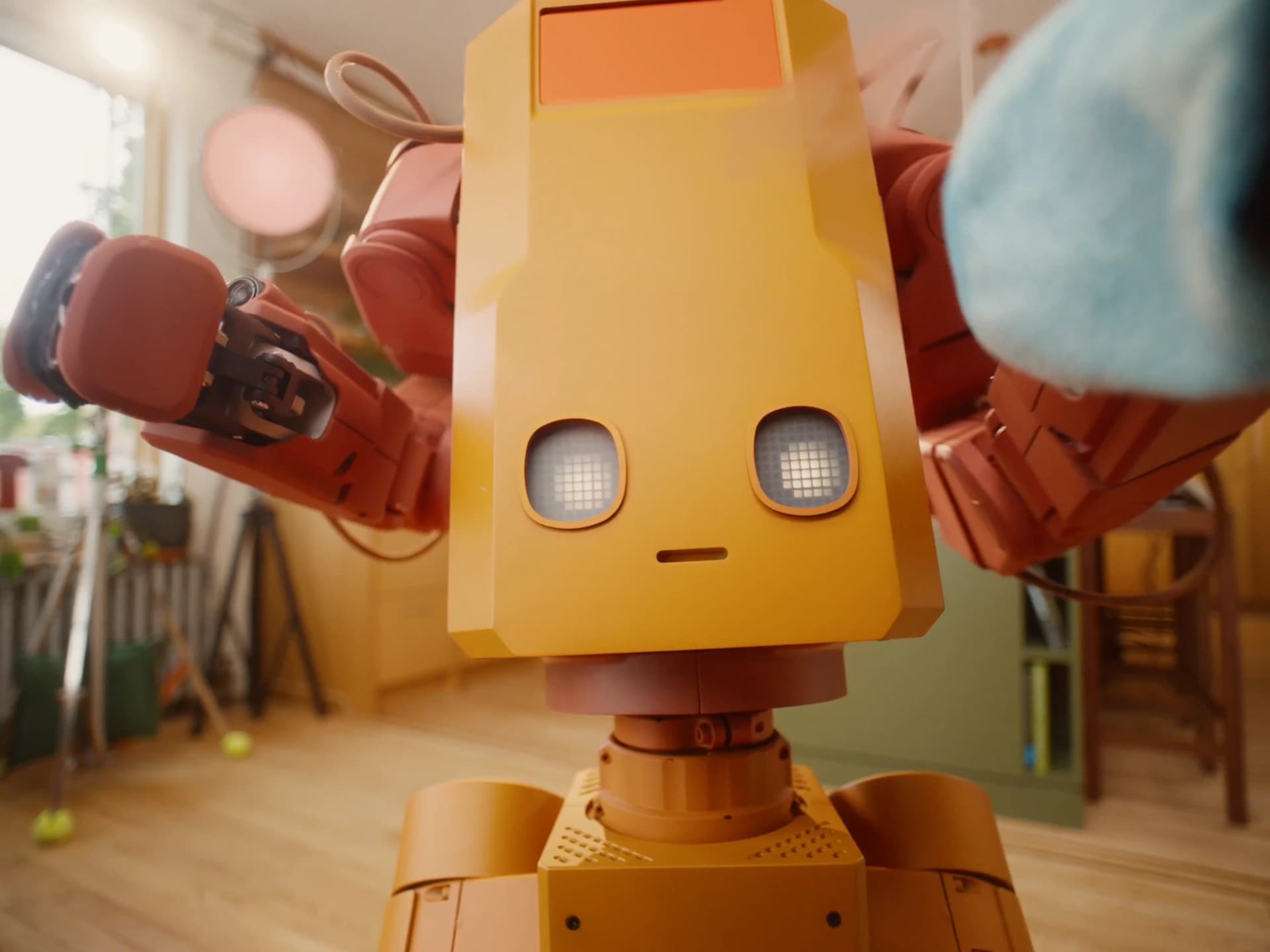 Close-up of Voxel’s illuminated eyes near the bottom of its tall yellow front panel.