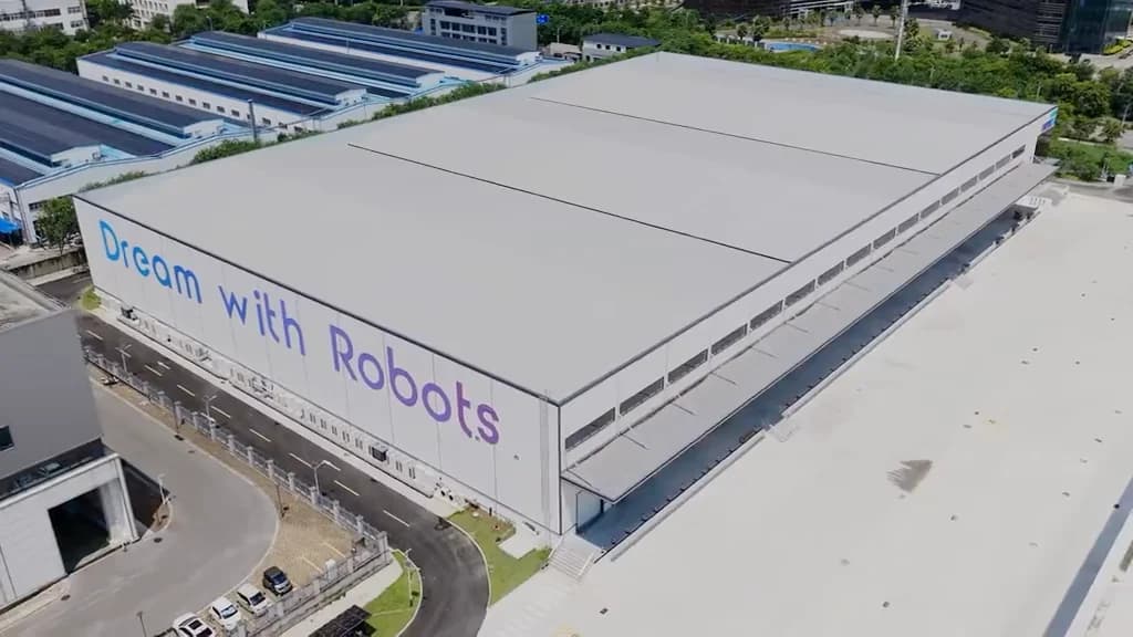 An aerial view of UBTECH's 14,000-square-meter Industrial Humanoid Robot Super Smart Factory in Liuzhou, Guangxi, featuring the slogan 'Dream with Robots' painted across its side exterior.
