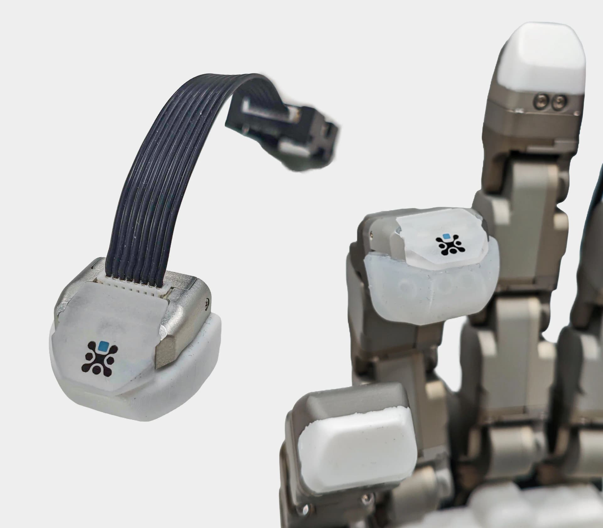 A composite image showing a standalone XELA Robotics uSkin sensor unit with a black ribbon cable on the left, and a close-up of a metallic Tesollo DG-5F robotic hand with the white uSkin sensors mounted on its fingertips on the right.