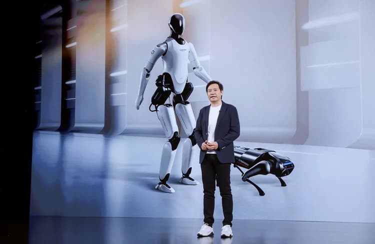 Xiaomi CEO Lei Jun stands on stage in front of a large screen displaying the white CyberOne humanoid robot on the left and the black CyberDog quadruped robot on the right.